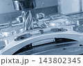 Inclined view of the rough cutting process on aluminum automotive parts using a wave edge cutter in a light blue scene 143802345
