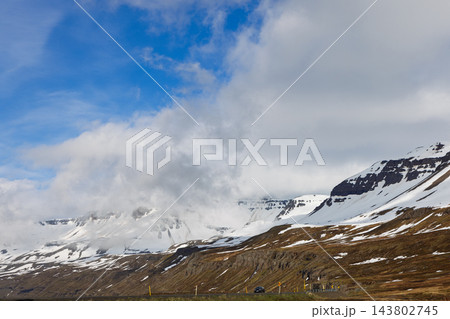 Snowy mountain slopes and valley road near Seydisfjordur in East Iceland Snowy mountain slopes and valley road near Seydisfjordur in East Iceland 143802745