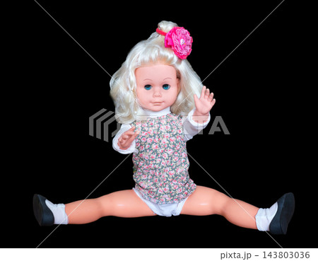 Miniature toy doll on a black background. Miniature toy doll on a black background. 143803036