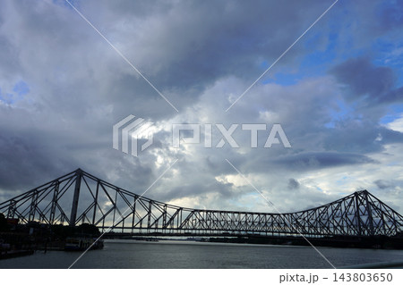 Majestic steel cantilever Howrah Bridge over Hooghly river under dramatic cloudy sky in Kolkata Majestic steel cantilever Howrah Bridge over Hooghly river under dramatic cloudy sky in Kolkata 143803650