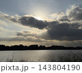 雲間から降り注ぐ光ときらめく水面 143804190
