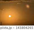 黄金色の空に輝く太陽と送電鉄塔のシルエット 143804265