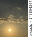 淡い金色の光に包まれる太陽と雲の空 143804267