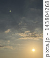 広い空にたなびく雲と右下に輝く太陽 143804268