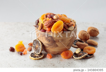 Assorted nuts and dried fruits in wooden dish. Assorted nuts and dried fruits in wooden dish. 143804395
