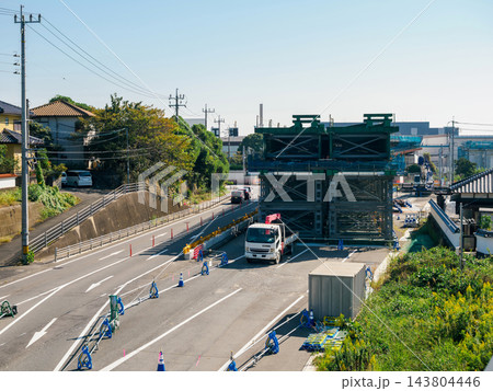 道路上空に架設される橋梁鋼桁と車線規制された現道の風景 道路上空に架設される橋梁鋼桁と車線規制された現道の風景 143804446
