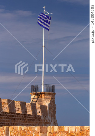 Greek Flag and Historic Stone Arch at Venetian Harbor in Chania, Crete 143804508