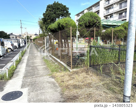 駐車場とフェンスに挟まれた団地敷地内のコンクリート歩道 駐車場とフェンスに挟まれた団地敷地内のコンクリート歩道 143805323