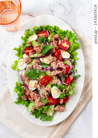 salad with canned tuna, cherry tomatoes, cucumber, and quail eggs on a white plate salad with canned tuna, cherry tomatoes, cucumber, and quail eggs on a white plate 143805419