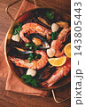 seafood and black rice paella, in a frying pan, homemade, on a wooden table, no people, 143805443