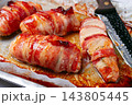 baked chicken breast, wrapped in bacon, on a baking tray. in the home kitchen.close-up. 143805445