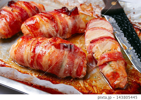 baked chicken breast, wrapped in bacon, on a baking tray. in the home kitchen.close-up. baked chicken breast, wrapped in bacon, on a baking tray. in the home kitchen.close-up. 143805445