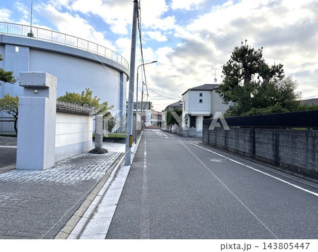 住宅街に隣接する大きな配水池と舗装道路の景観 143805447