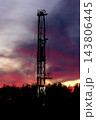 Silhouettes of trees and oil rig in the purple sunset light. 143806445