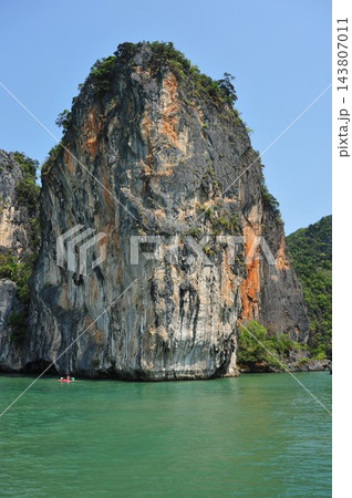 タイ・パンガー湾の海にそびえる巨大な岩峰と小さなカヤック 縦位置 タイ・パンガー湾の海にそびえる巨大な岩峰と小さなカヤック 縦位置 143807011