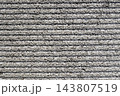 グレーの凹凸があるコンクリート壁。横縞が連なる粗い背景テクスチャ 143807519