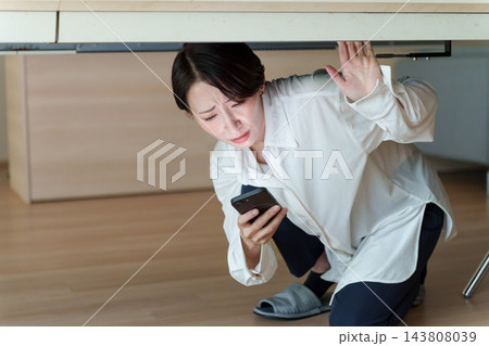 スマートフォンで災害情報を確認する女性 スマートフォンで災害情報を確認する女性 143808039