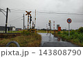 雨に濡れた踏切と水たまりのある道路 143808790