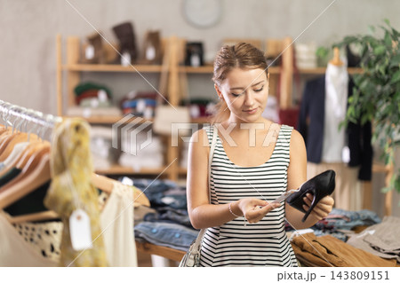 Young beautiful girl chooses fashionable shoes in prestigious store Young beautiful girl chooses fashionable shoes in prestigious store 143809151