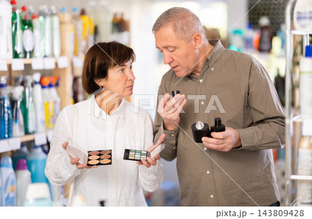 Elderly couple choosing perfumes and cosmetics Elderly couple choosing perfumes and cosmetics 143809428
