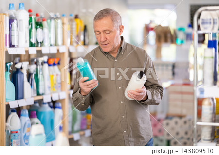 Elderly man choosing a shower gel and shampoo Elderly man choosing a shower gel and shampoo 143809510