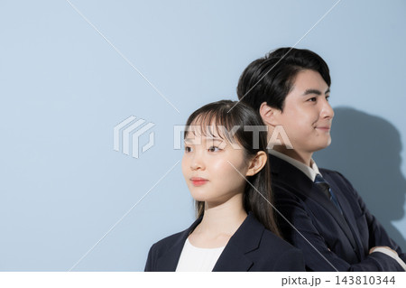 背中合わせに立ち未来を見つめる20代～30代の日本人男女のビジネス 143810344