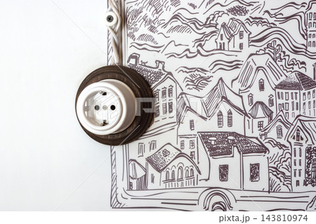 Round ceramic wall socket beside a monochrome city illustration Round ceramic wall socket beside a monochrome city illustration 143810974