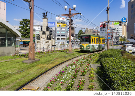 鹿児島市鹿児島中央駅前電停に入ってくる路面電車 143811026