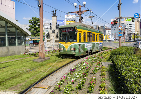 鹿児島市鹿児島中央駅前電停に入ってくる路面電車 143811027