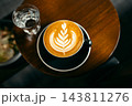 Top view of hot coffee latte art cup on small round wooden table 143811276
