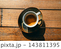 Close-up top view of a perfect espresso shot with golden crema in a ceramic cup on a wooden table 143811395