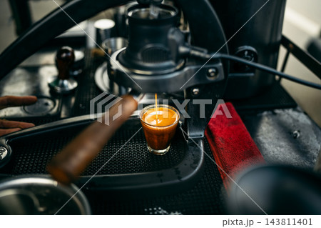 Barista brewing specialty coffee using a manual lever espresso machine at a slow bar. 143811401