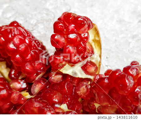 Close up fresh juicy red pomegranate arils on crushed ice 143811610
