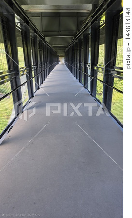 奥行きのある黒い金属フレームの歩道橋内部（建築構造・直線美・遠近感） 143813148