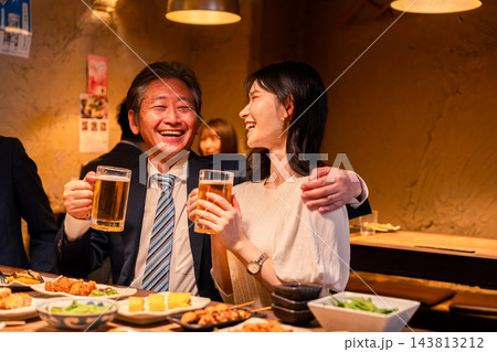飲み会で女性社員と肩を組む男性 143813212