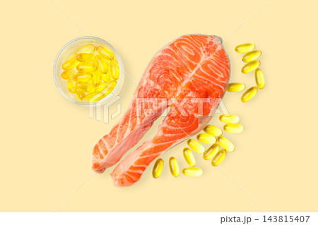 Omega 3. Salmon fillet placed next to fish oil capsules on light background. Omega 3. Salmon fillet placed next to fish oil capsules on light background. 143815407
