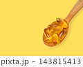 Omega 3. Golden fish oil capsules rest on wooden spoon. Omega health supplement concept. 143815413