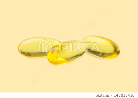Omega 3. Three smooth softgel capsules of omega 3 fish oil placed on a soothing backdrop. 143815416