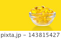 Omega 3. Bowl contains shiny omega fish oil capsules ready for consumption. 143815427