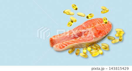 Omega 3. Salmon fillet is surrounded by vibrant fish oil capsules. 143815429