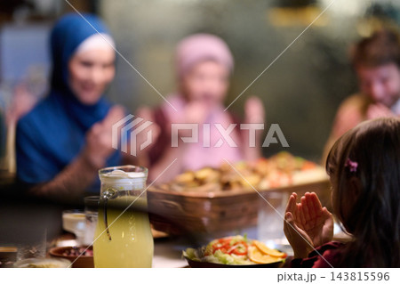 Muslim Family Saying Prayer Together Over Iftar Dinner at Home During Ramadan Muslim Family Saying Prayer Together Over Iftar Dinner at Home During Ramadan 143815596