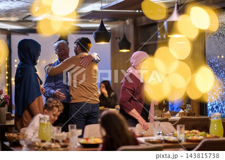 Multigenerational Muslim Family Reunion Hugging During Festive Dinner At Cozy Restaurant With Warm Lights Multigenerational Muslim Family Reunion Hugging During Festive Dinner At Cozy Restaurant With Warm Lights 143815738