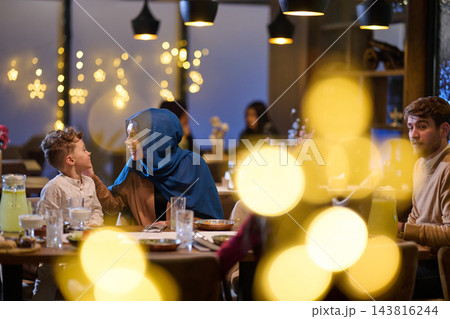 Family Sharing Warm Conversation and Dinner in a Festive Restaurant With Soft Bokeh Lights Family Sharing Warm Conversation and Dinner in a Festive Restaurant With Soft Bokeh Lights 143816244