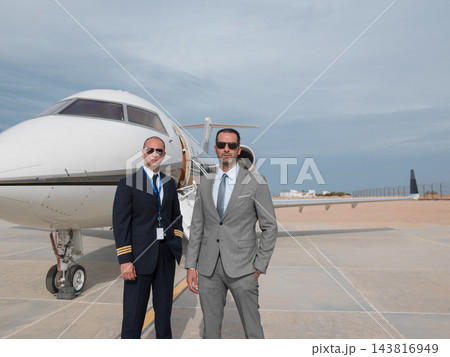 Middle Eastern business team standing by private jet at airport runway in professional suits 143816949