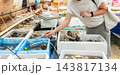 魚屋で活貝を品定めする女性　マーケットでの買い物 143817134