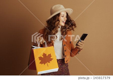 Joyful Autumn Shopper Laughing at Phone Joyful Autumn Shopper Laughing at Phone 143817379
