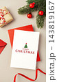 Merry christmas greeting card on red envelop with gift box, red ribbon and xmas ornament on beige background 143819167