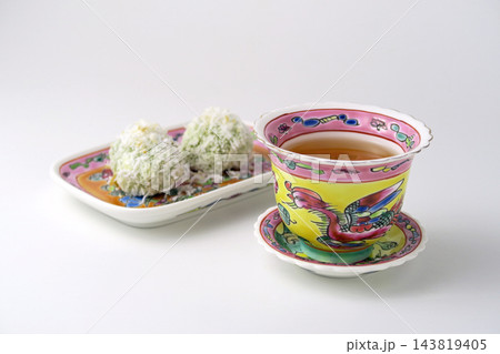 白背景にマレーシアのカラフルなプラナカン陶器のセットにプラナカン菓子でティータイム 143819405