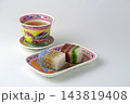 白背景にマレーシアのカラフルなプラナカン陶器のセットにプラナカン菓子でティータイム 143819408