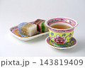白背景にマレーシアのカラフルなプラナカン陶器のセットにプラナカン菓子でティータイム 143819409